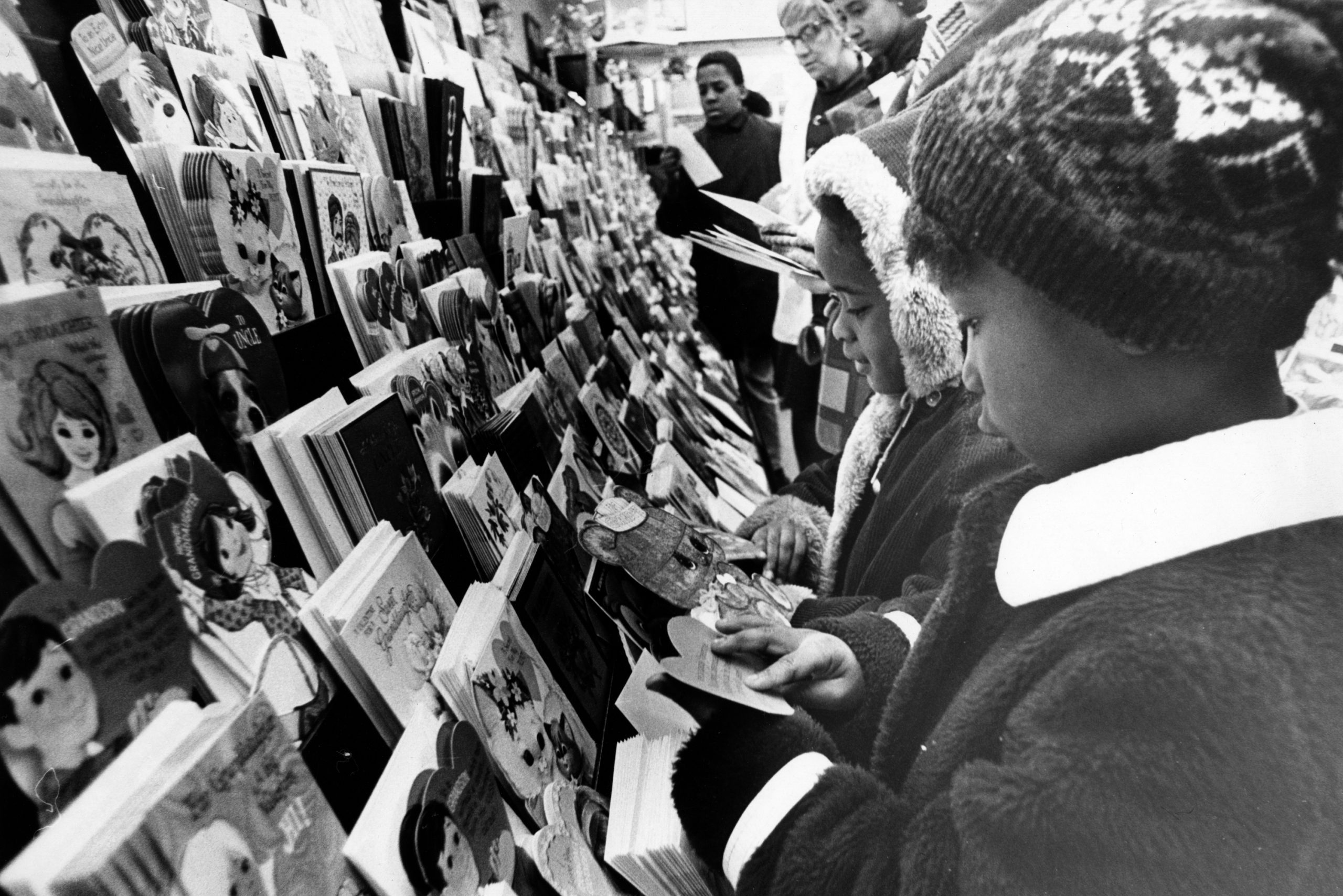 BOSTON, MA - FEBRUARY 12: Jackie Brown, 7, and Valerie Wilson, 5, flip through Valentine's Day cards at the Bayside Mall in Boston on Feb. 12, 1970. (