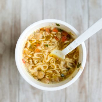 instant cup of ramen noodles from above on light wood surface