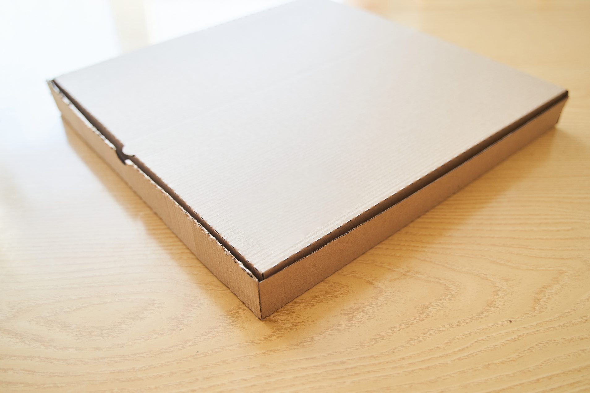 brown cardboard Pizza box on a wood table surface