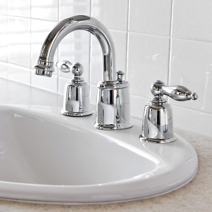 Close-up of white bathroom vanity with silver faucet