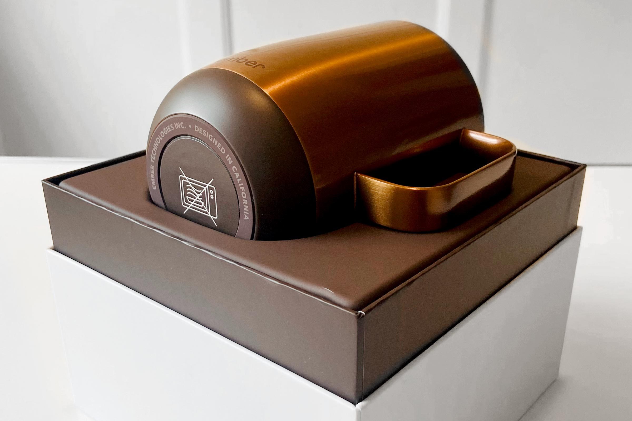 a copper ember mug in an open box on a white table in a home