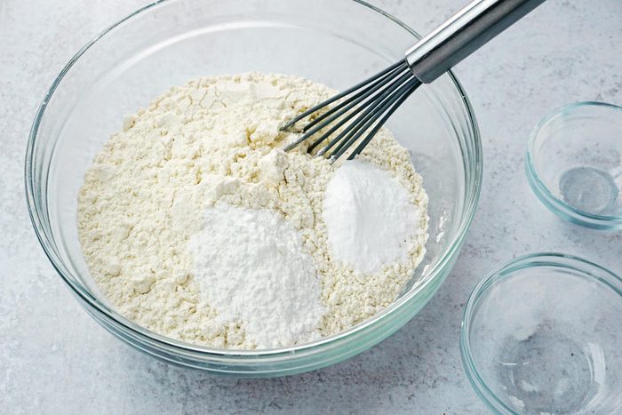 large glass bowl with dry ingredients for baking and a whisk
