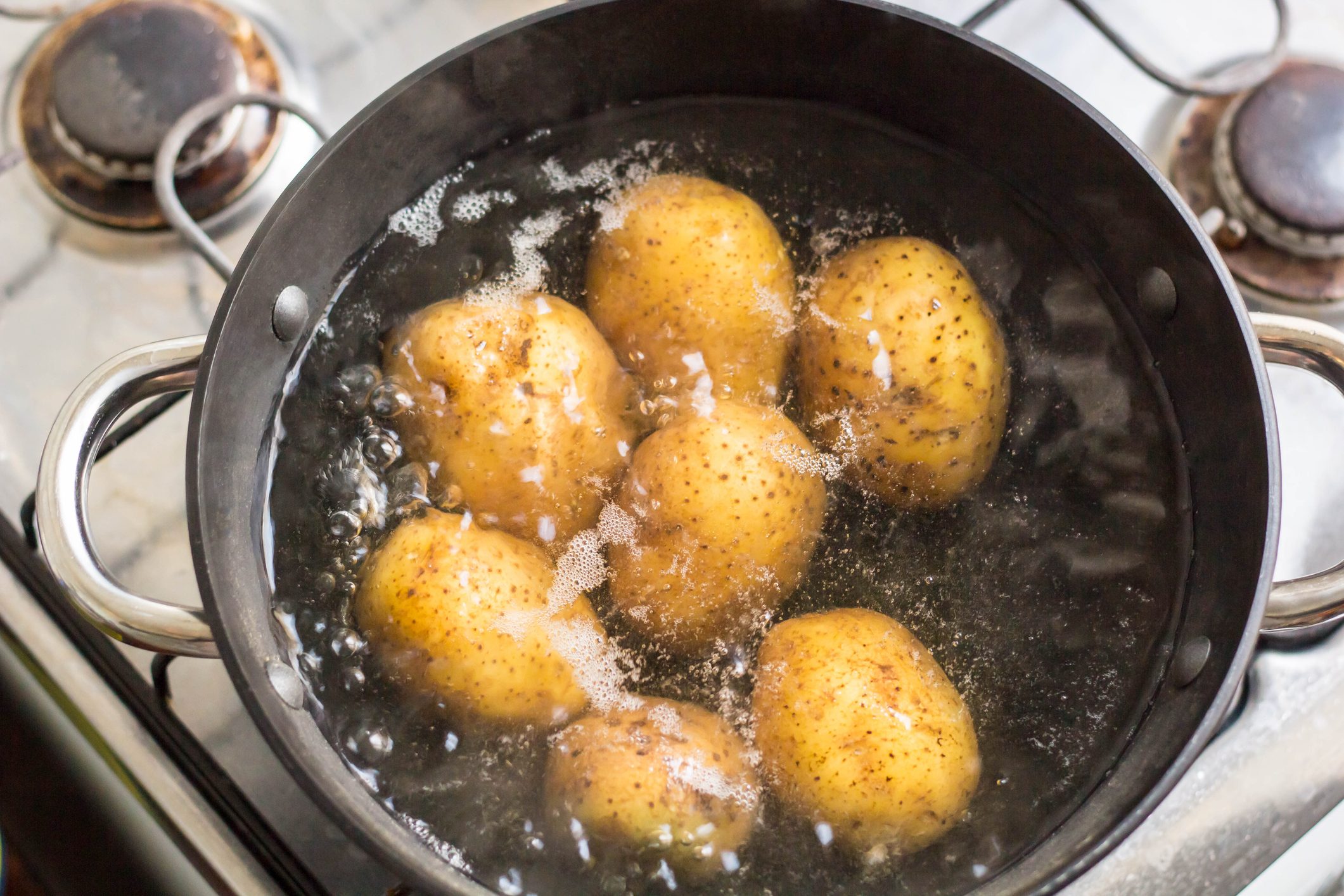 Potatoes boiling in a pot on the stove