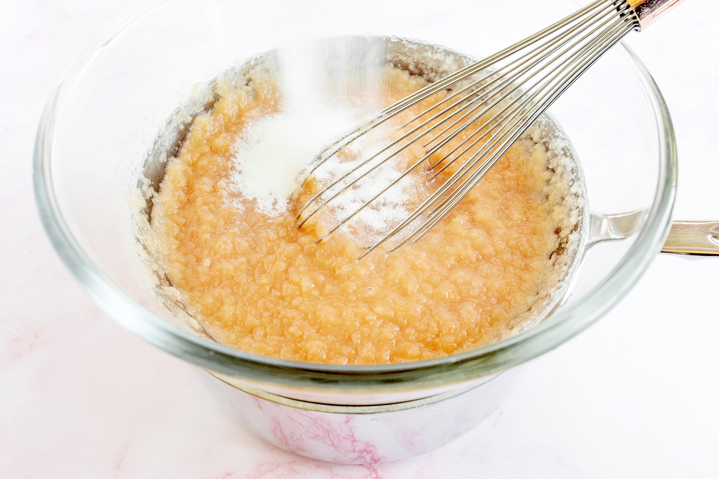 mixing ingredients for strawberry cloud cake with a whisk