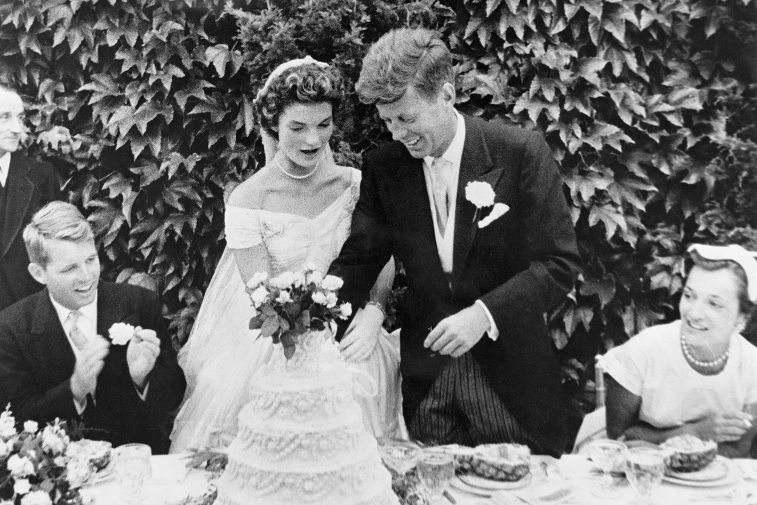 John F. Kennedy and Jacqueline Bouvier cutting their wedding cake after their marriage in Newport, Rhode Island