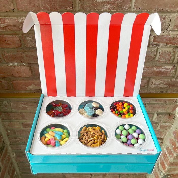 inside a sugar wish candy box with six circular containers filled with various candies and snacks