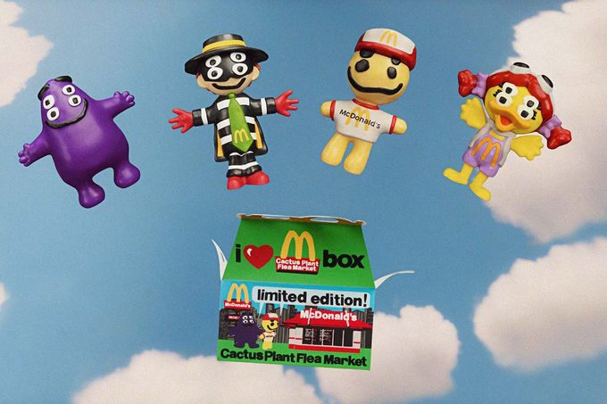 McDonald's adult happy meal with nostalgic toys on a vintage blue sky with clouds background