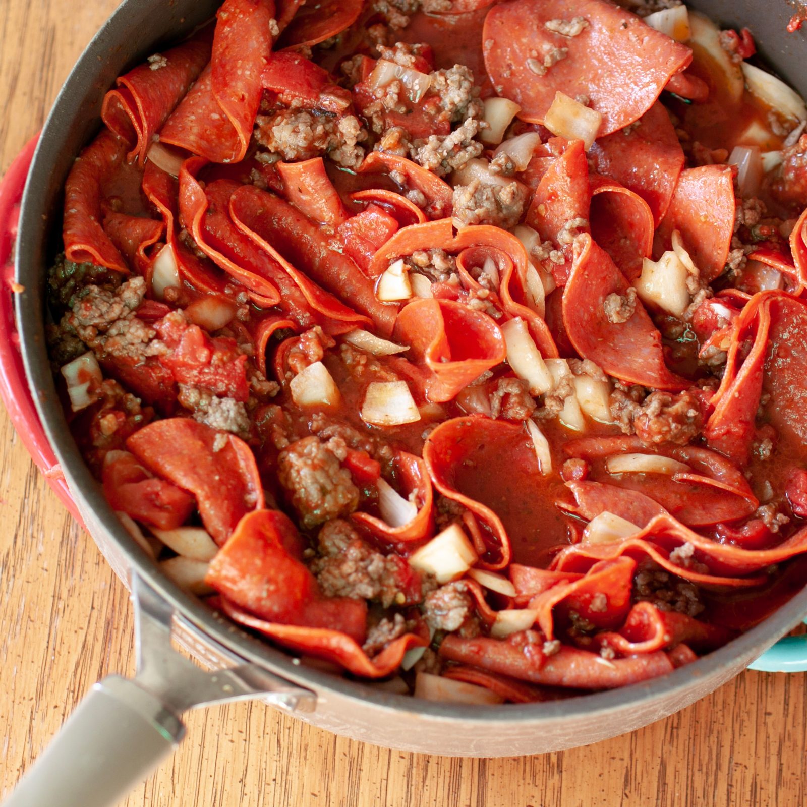 pepperoni, tomatoes, tomato paste, oregano, salt, pepper, garlic, onion in a pot