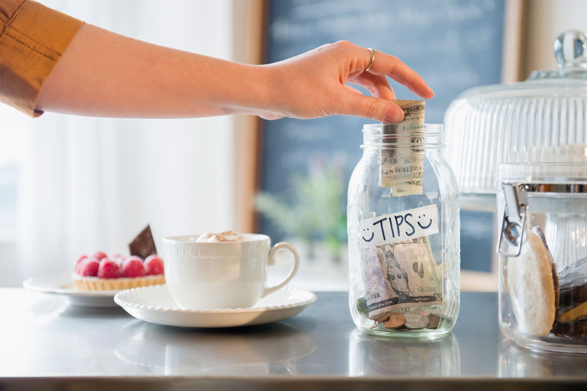 Caucasian Woman Putting Money In Tip Jar