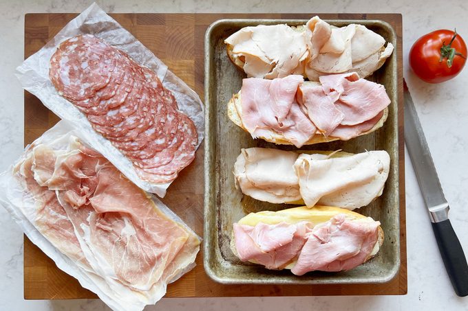meat on bread while assembling grinders