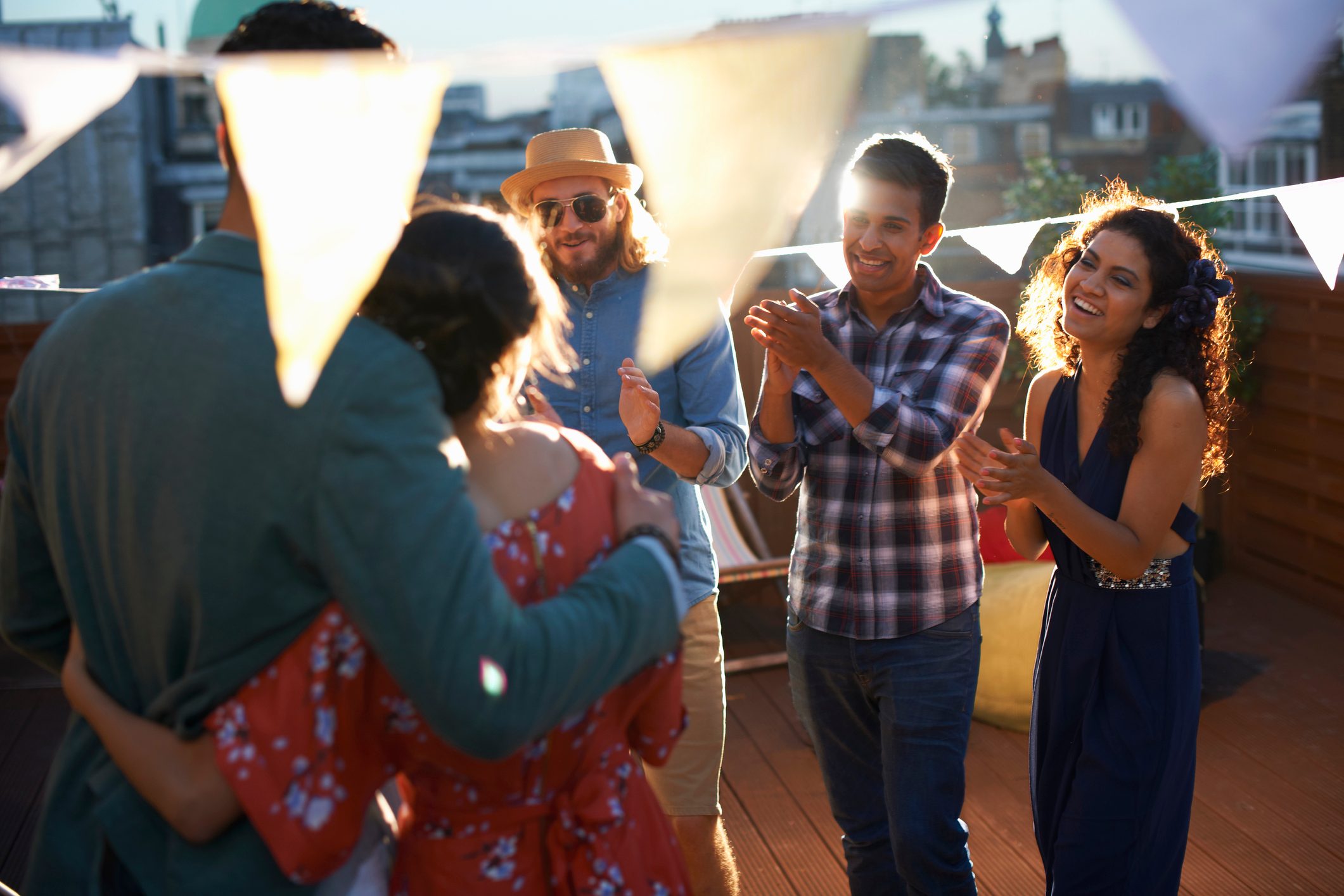 Friends congratulating couple at early evening engagement party
