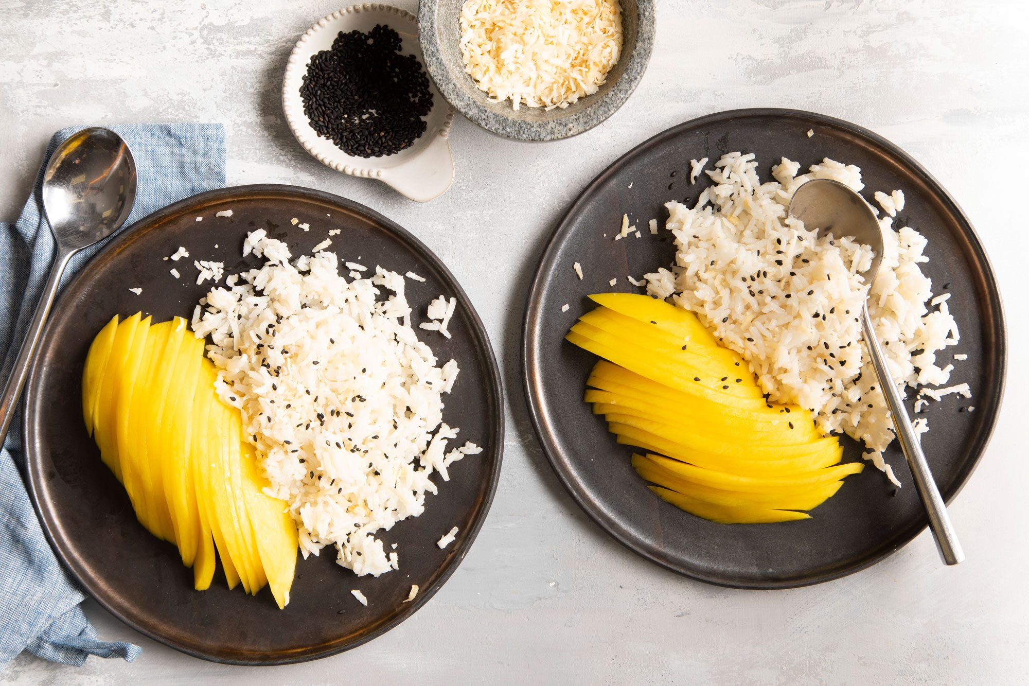 Coconut Rice with mango slices on black plates