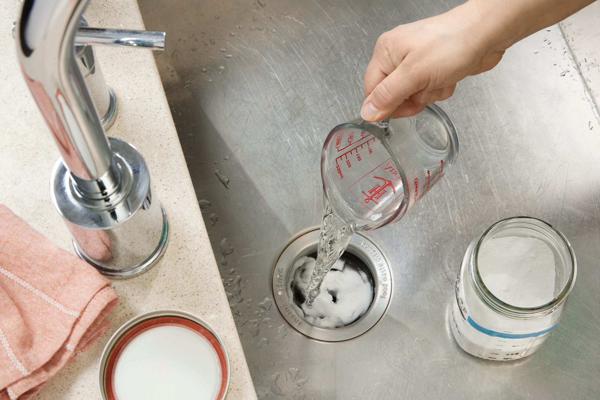 Hand Pouring Boiling Water Into Drain to create bubbling with drain cleaner already in drain