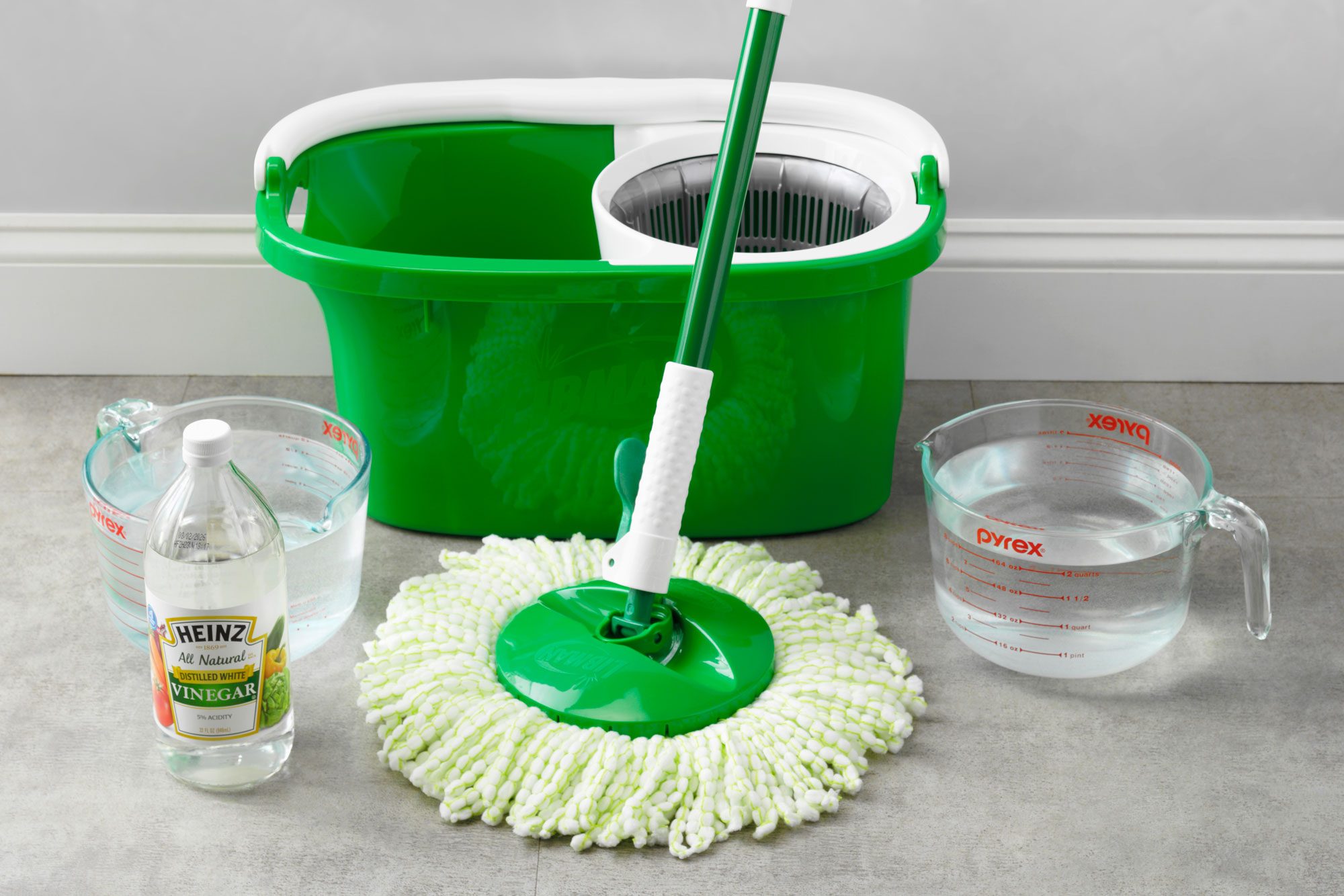 supplies for homemade vinyl floor cleaner arranged on a vinyl floor near the wall