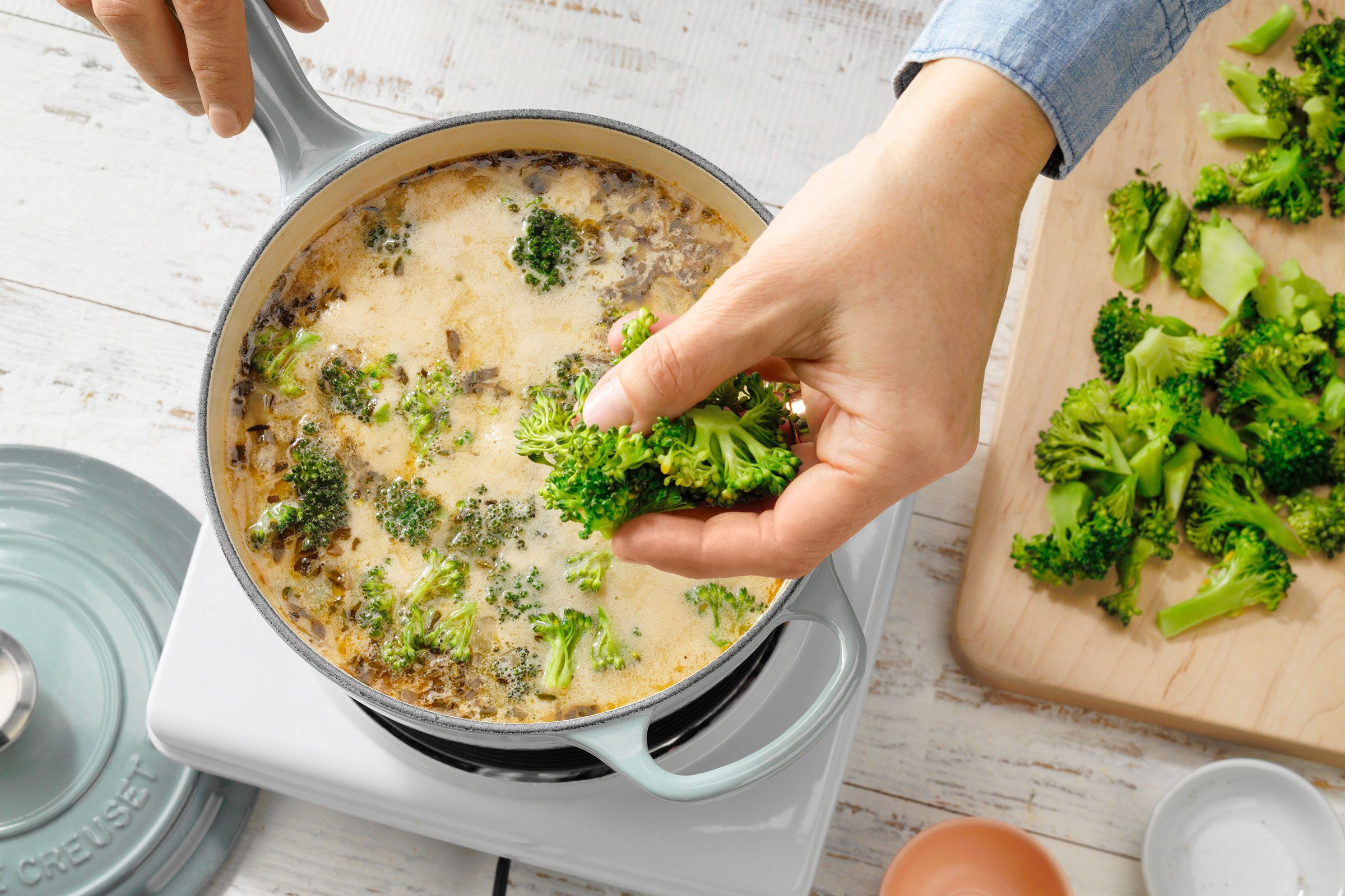 Pot With Hand Dropping In Broccoli