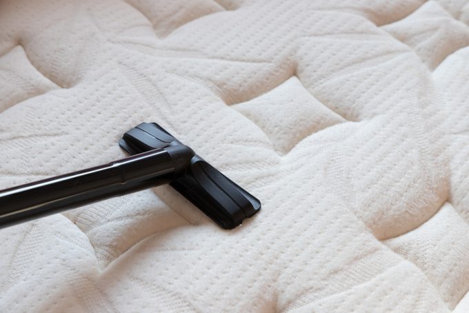 cleaning mattress by vacuum cleaner. dust mites on bed, texture. concept : allergy in bed room.