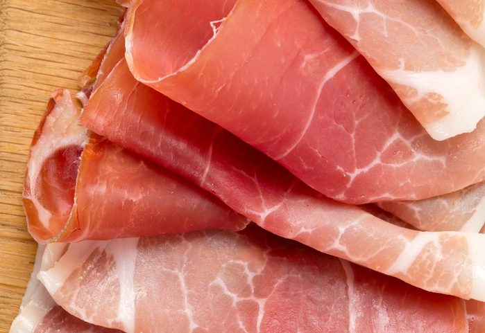 sliced prosciutto on a wooden board