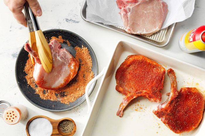 Pork Chops Coated With Spice Rub Placed In A Baking Dish
