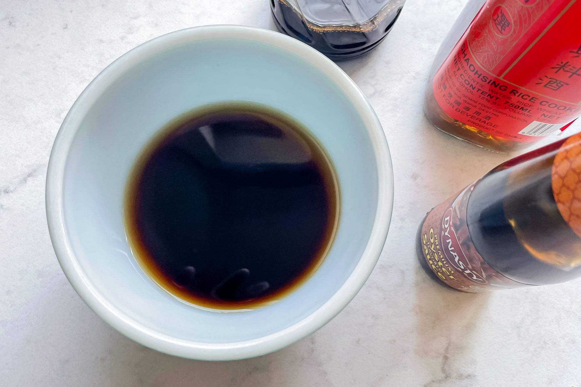 Sauces in Bowl on Marble Surface with Sauce bottles