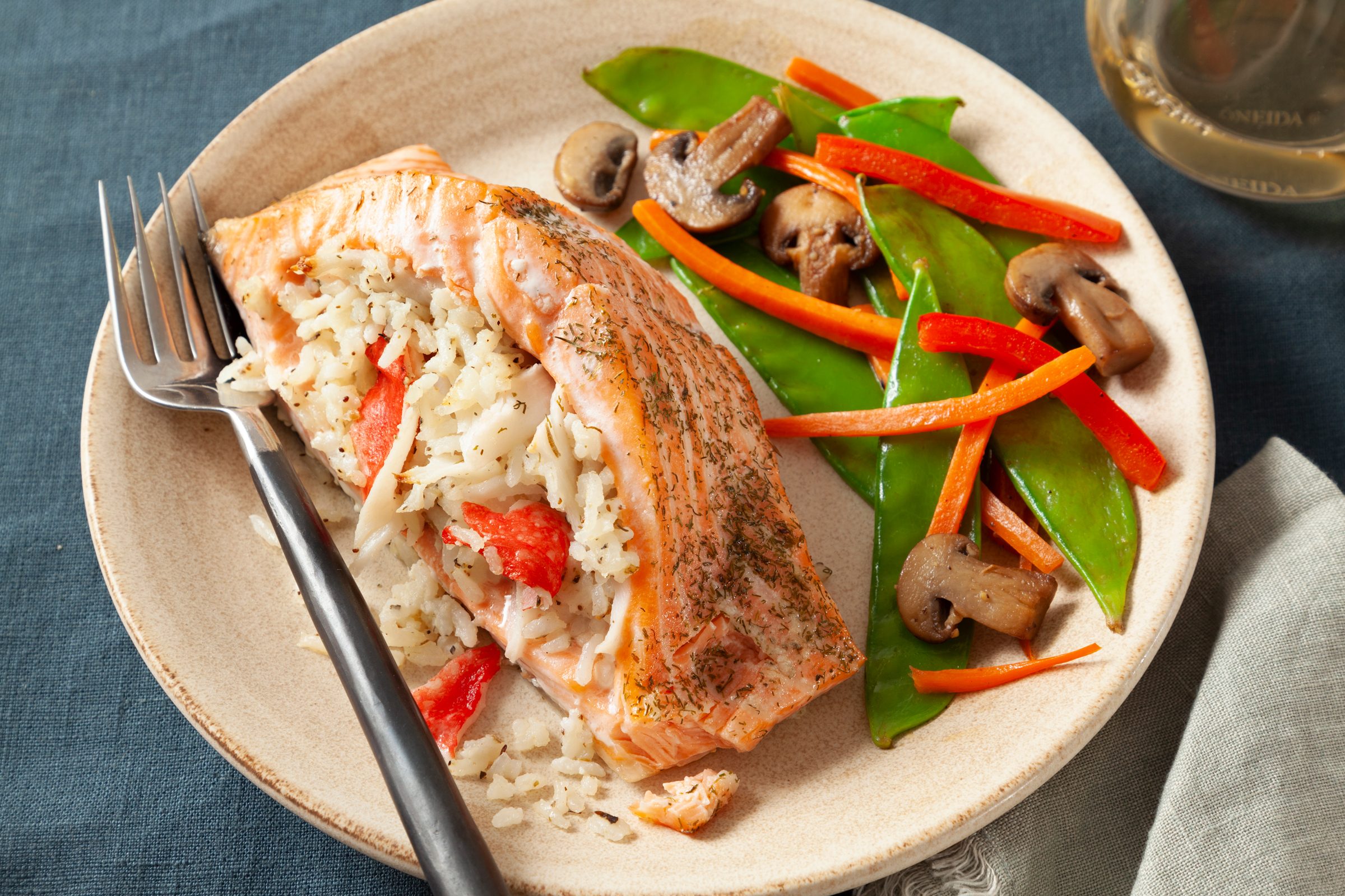 stuffed salmon on a plate with a fork and a side of mixed veggies