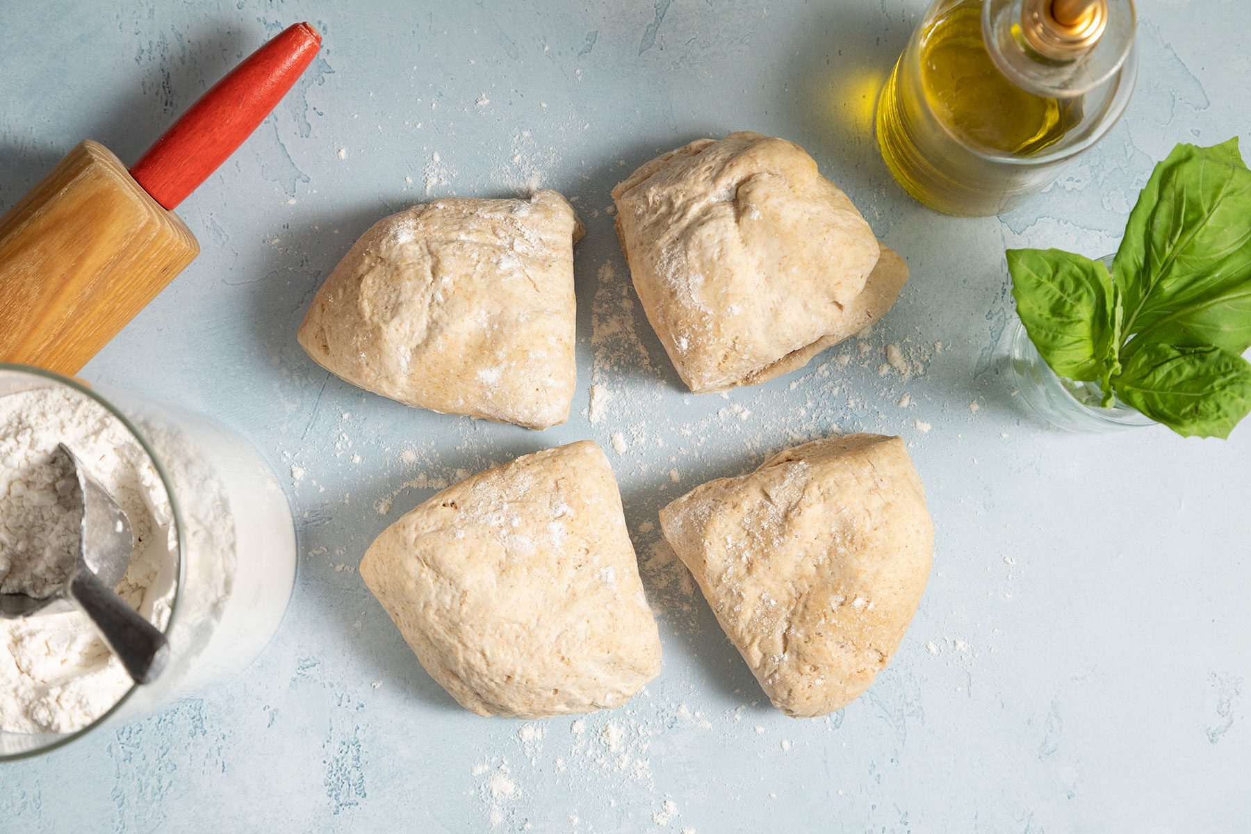 Dough in 4 pieces on blue surface
