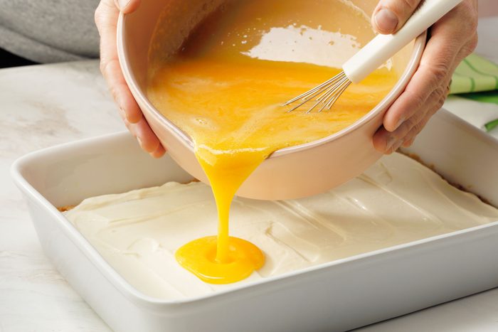 Pouring the egg and key lime juice mixture over the cream cheese layer