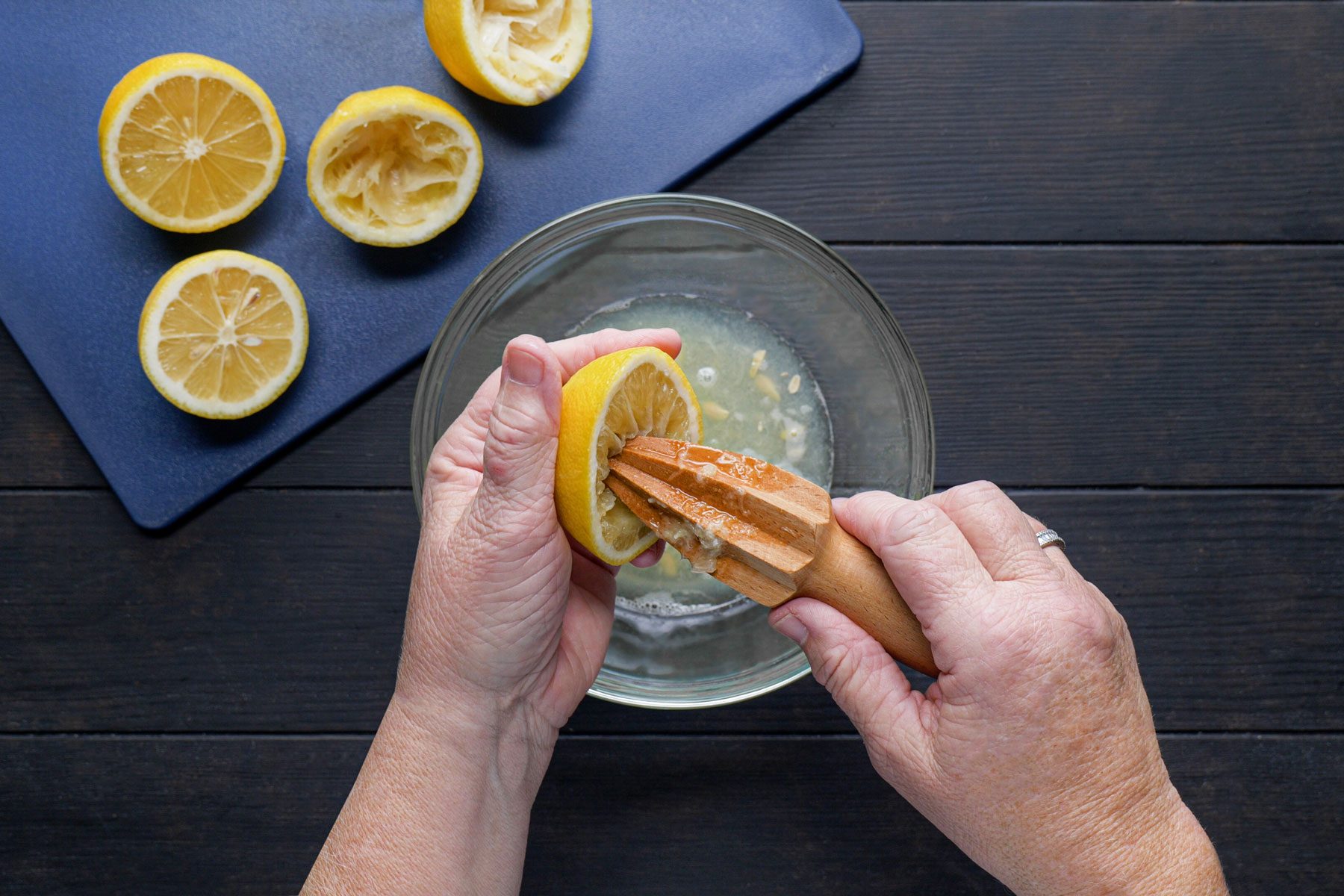 squeezing the lemon juice into a large bowl using citrus reamer
