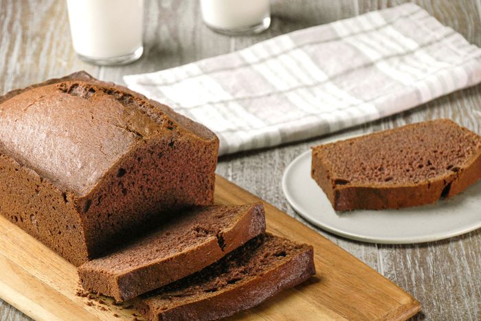 Chocolate Banana Bread served on a wooden surface with a glass of milk
