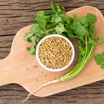 Coriander seeds and Cilantro on cutting board
