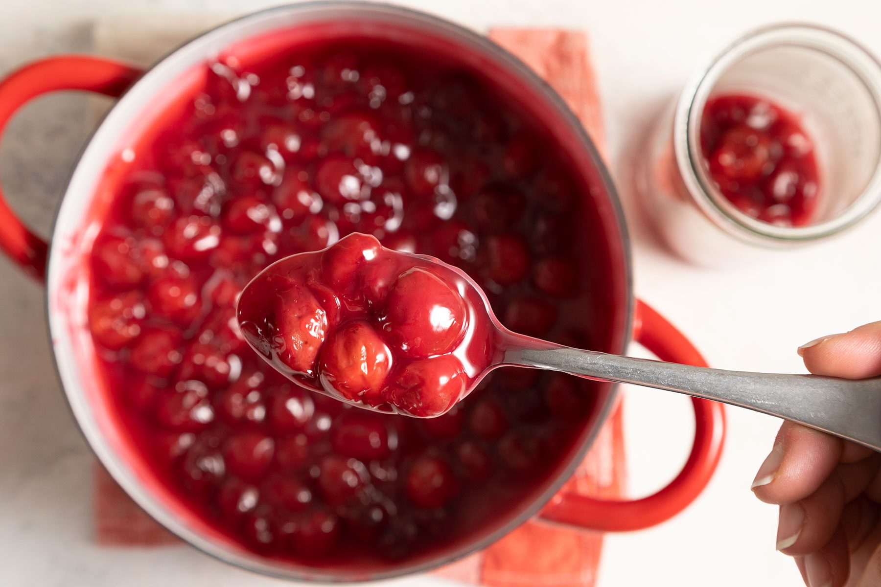 Picking spoonful of cooked cherry filling