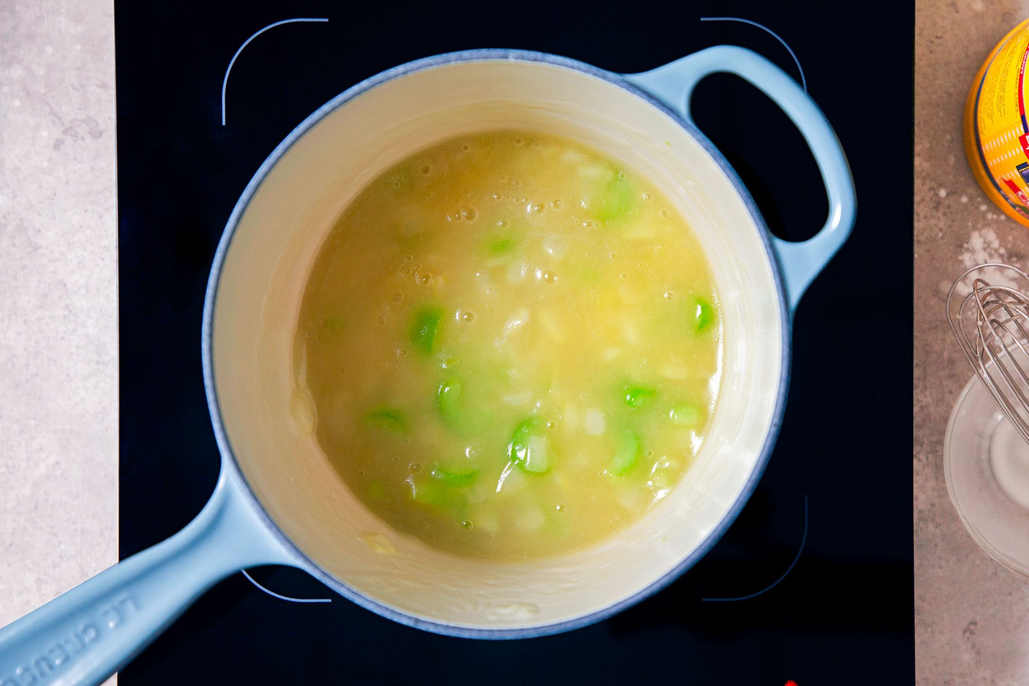 Onion and Celery Soup Boiling in A Saucepan on Induction Cooktop on A Marble Kitchen Top