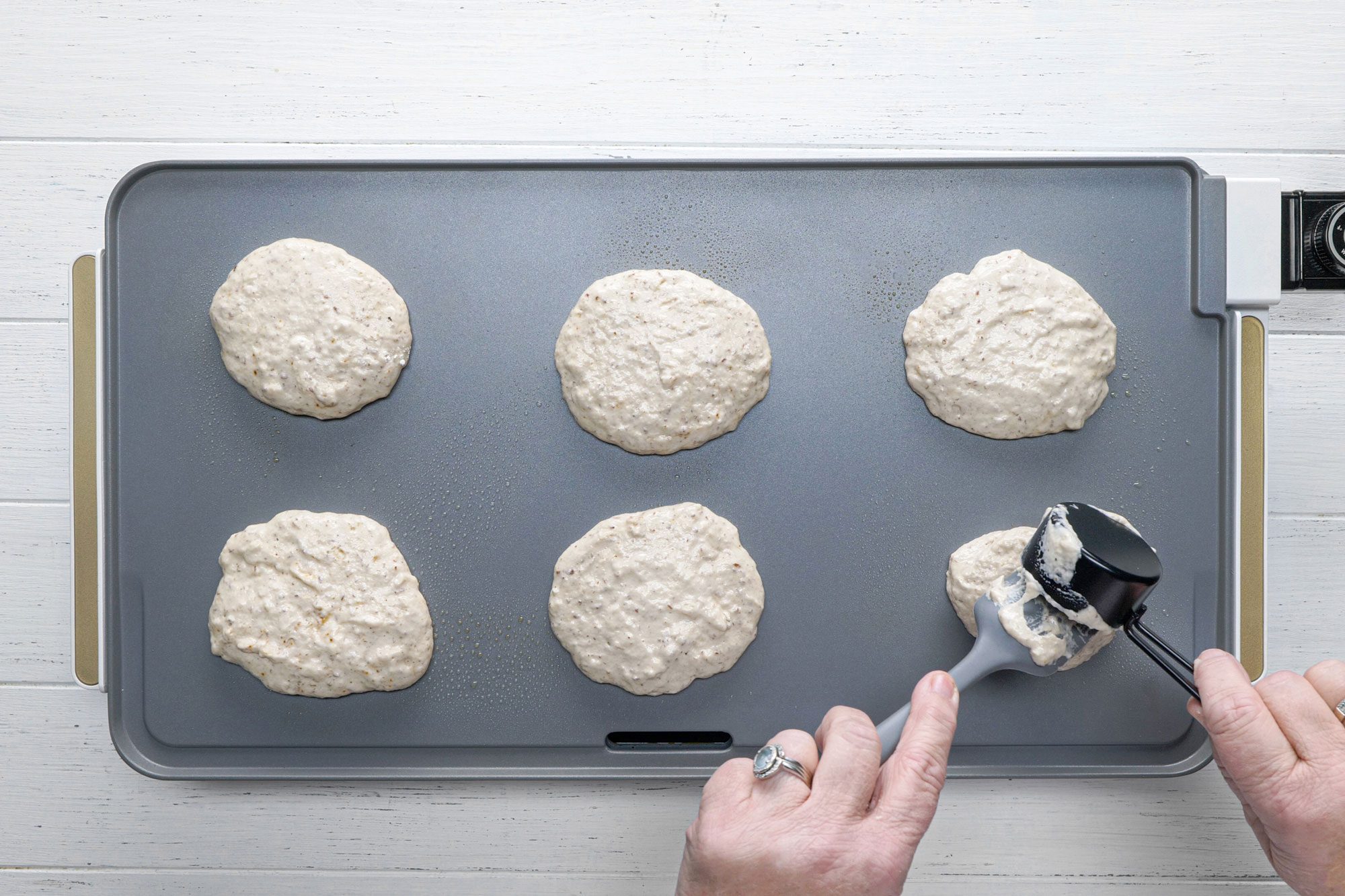 Pour pancake batter onto the warmed griddle using batter dispenser
