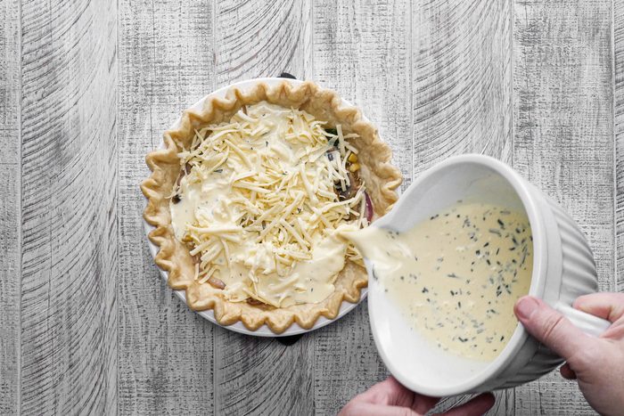 Pour the mixture over the cheese and vegetable filling in the pie crust