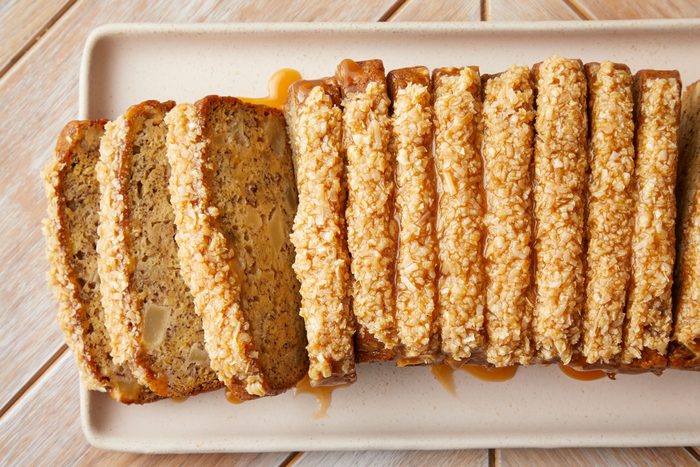 A plate of sliced Apple Banana Bread served with coconut glazed topping