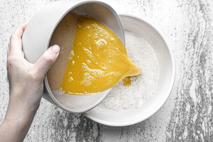 Whisking wet ingredients with dry ingredients in a bowl
