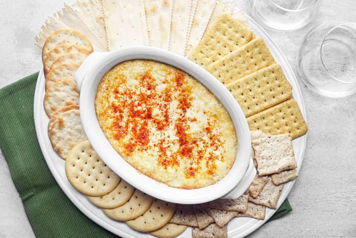 Artichoke Dip served with crackers in a large white plate
