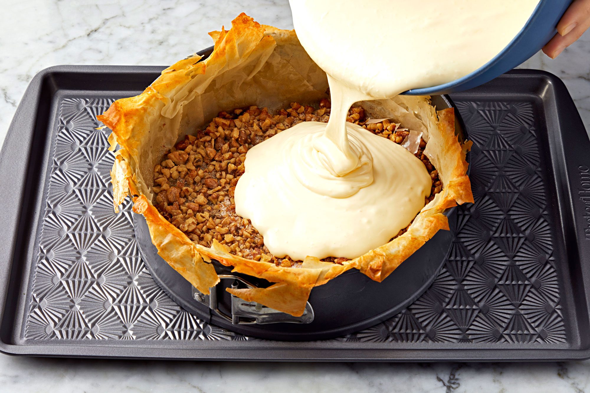 Pour the cheesecake batter into the crust and all over the walnut mixture