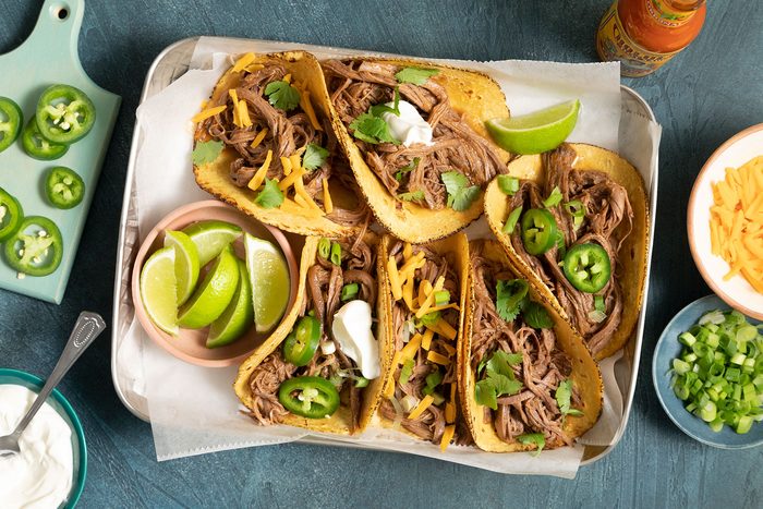 Brisket Tacos topped with lemon, jalapeños and cheese and served on plate