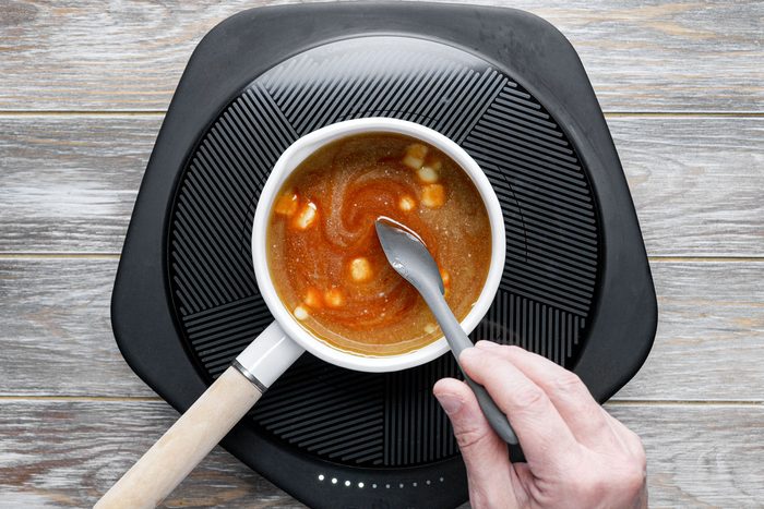 Cooking the sauce in a small white pan, mixing with spatula