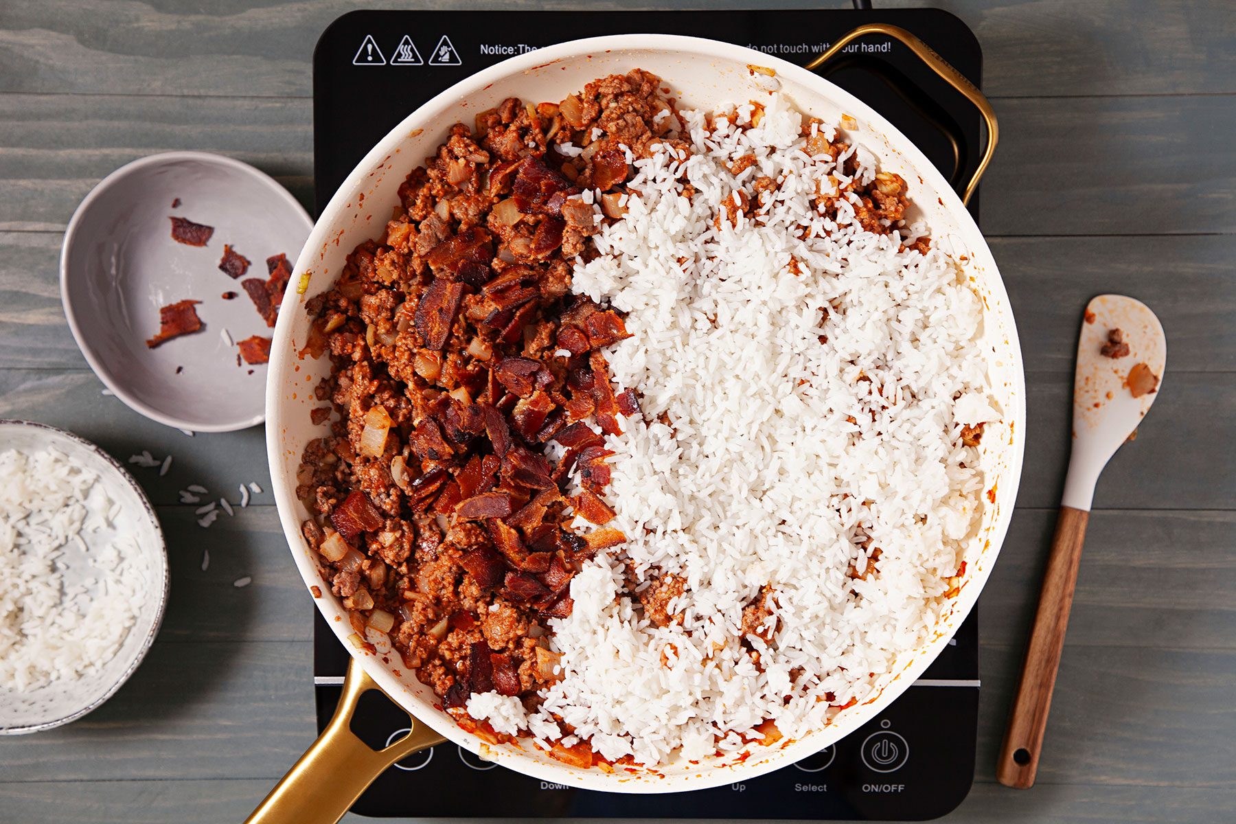 Rice and bacon added over beef mixture in sauce pan