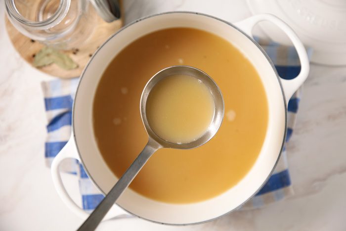 A bowl of chicken broth with a spoon