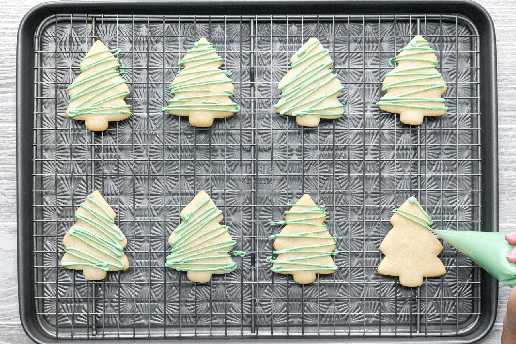 Decorating Christmas Sugar Cookies with food coloring on a cooling tray