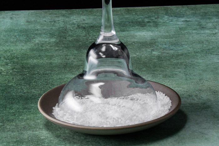 An overturned glass on a plate with salt scattered around it
