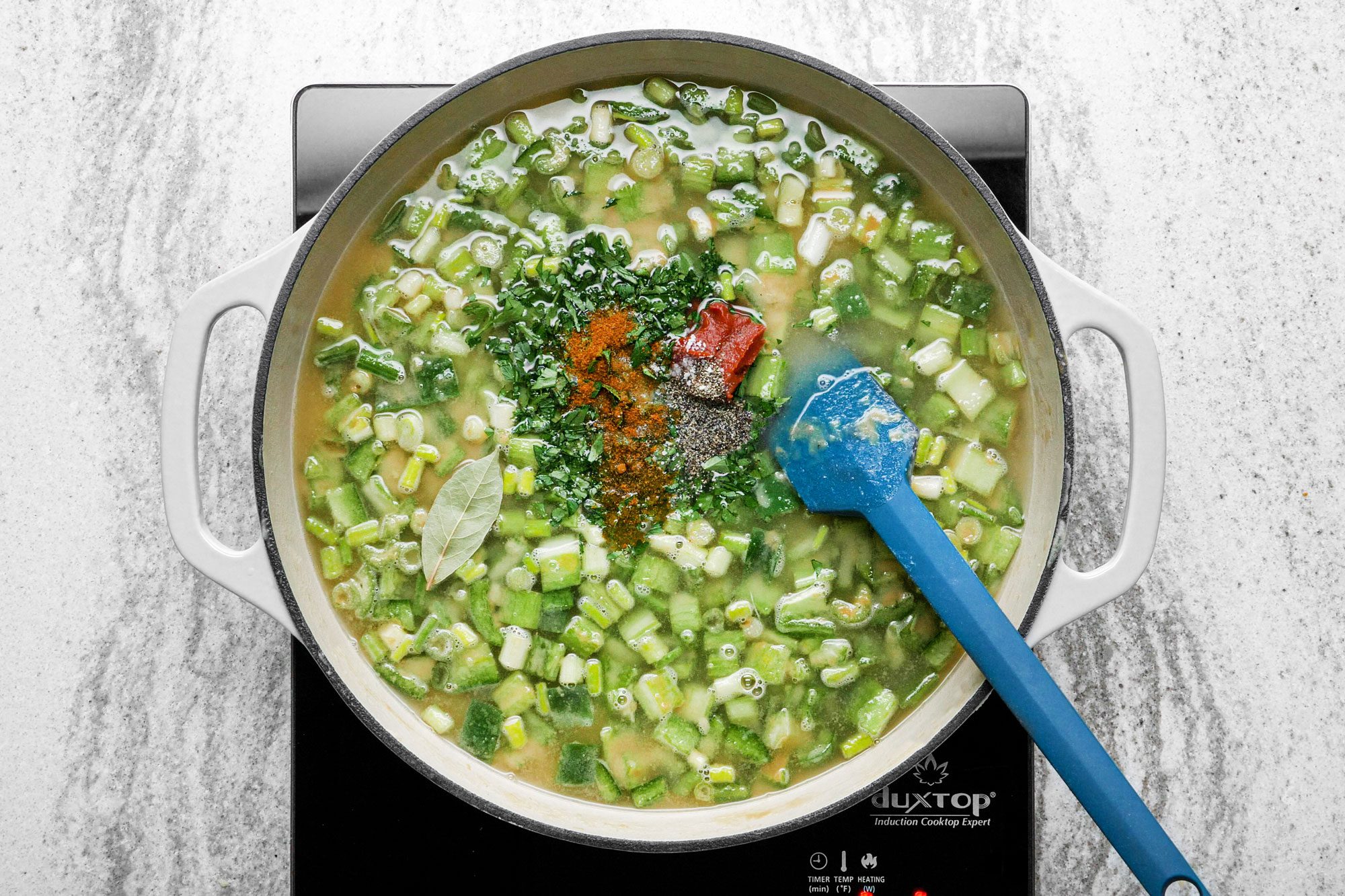 Mix broth, parsley, tomato paste, bay leaf, cayenne pepper, salt and pepper in the skillet