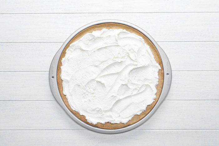 Cream cheese frosting on pizza base