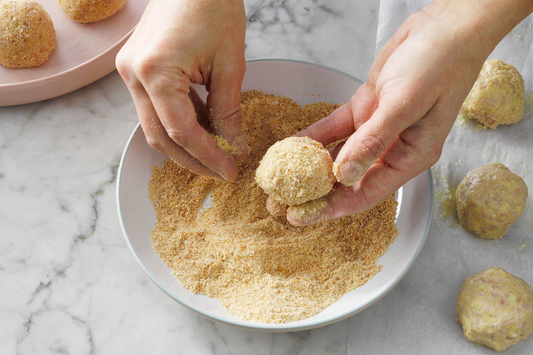 Coating the ham balls in bread crumbs