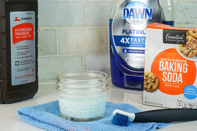 Cleaning products with a toothbrush placed on a white surface