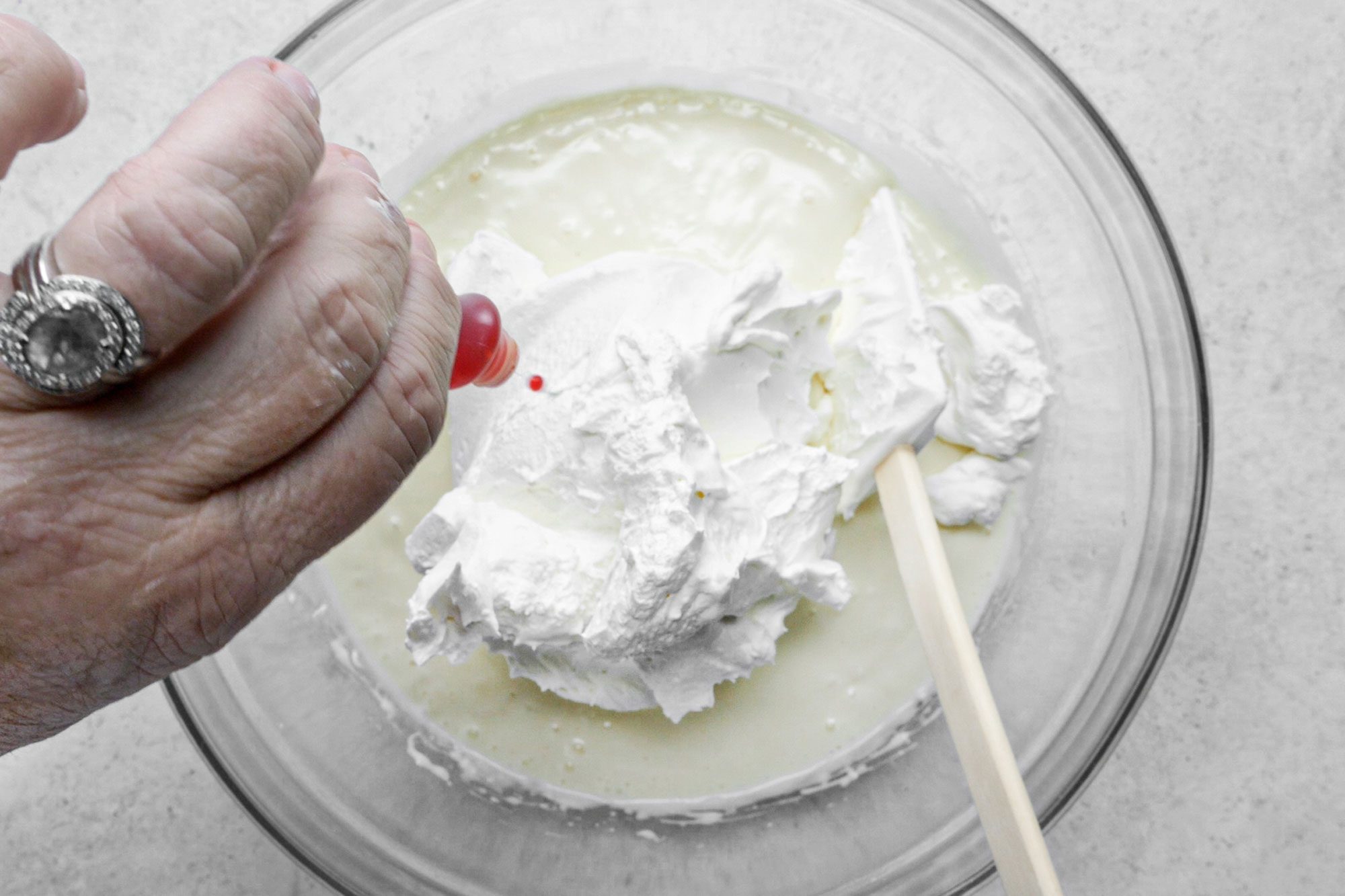 adding food coloring on pie mixture in a large glass bowl