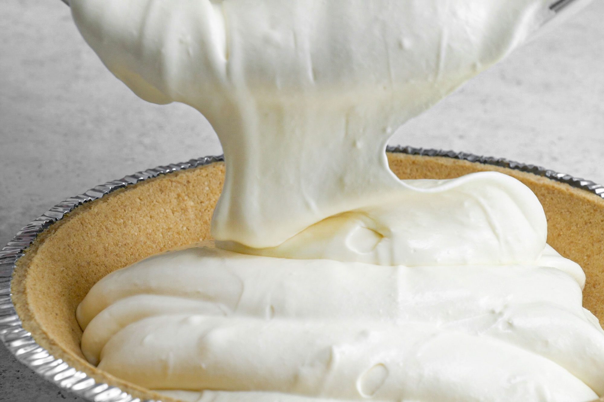 pouring pie filling on the pie crust