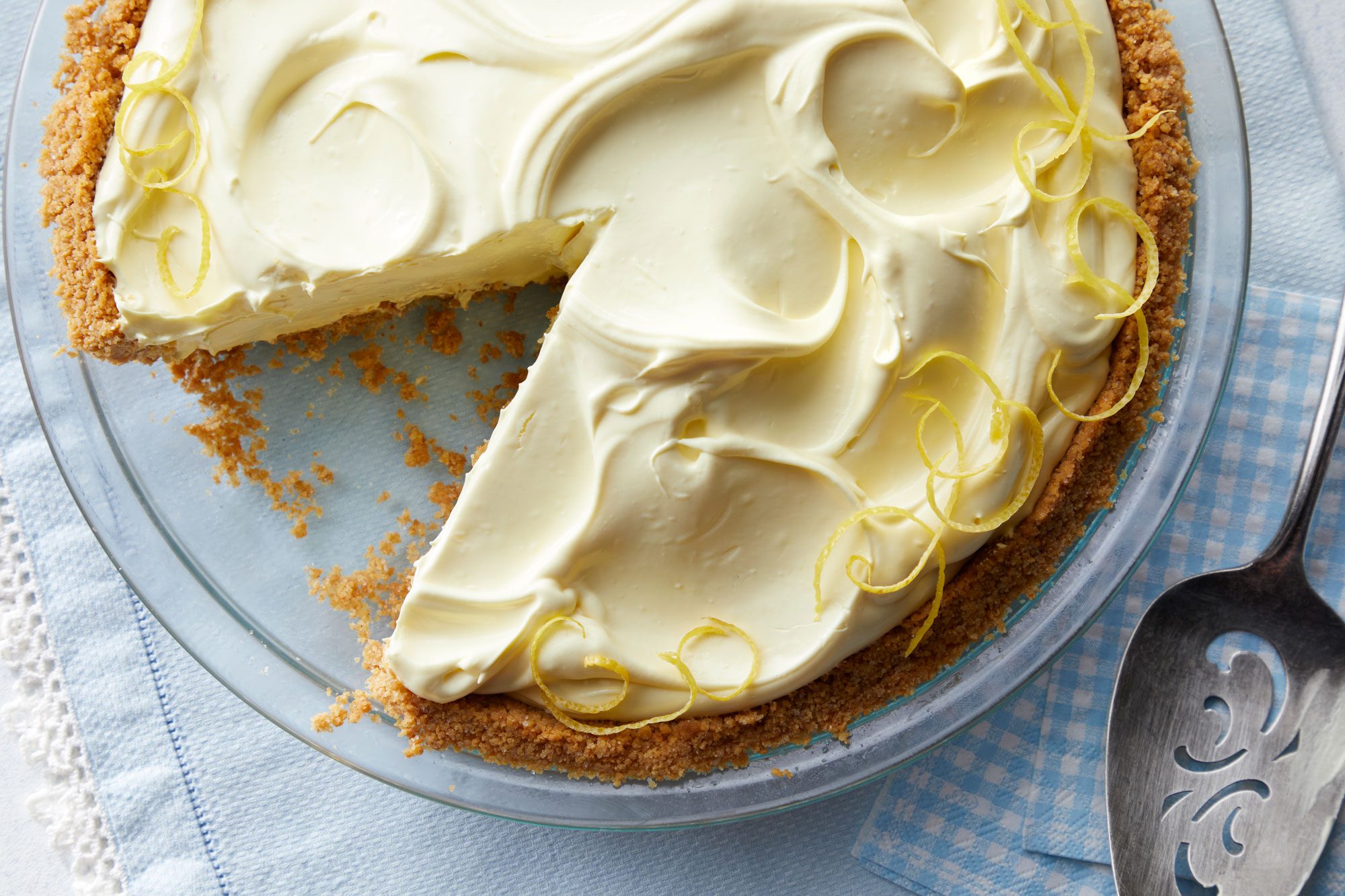Lemonade Icebox Pie on a glass pie plate and a spoon next to it
